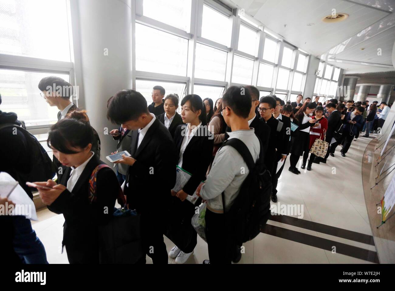 Chinese job seekers queue up to have a talk with interviewers to look for employment in financial sector at a job fair in Shanghai, China, 16 October Stock Photo