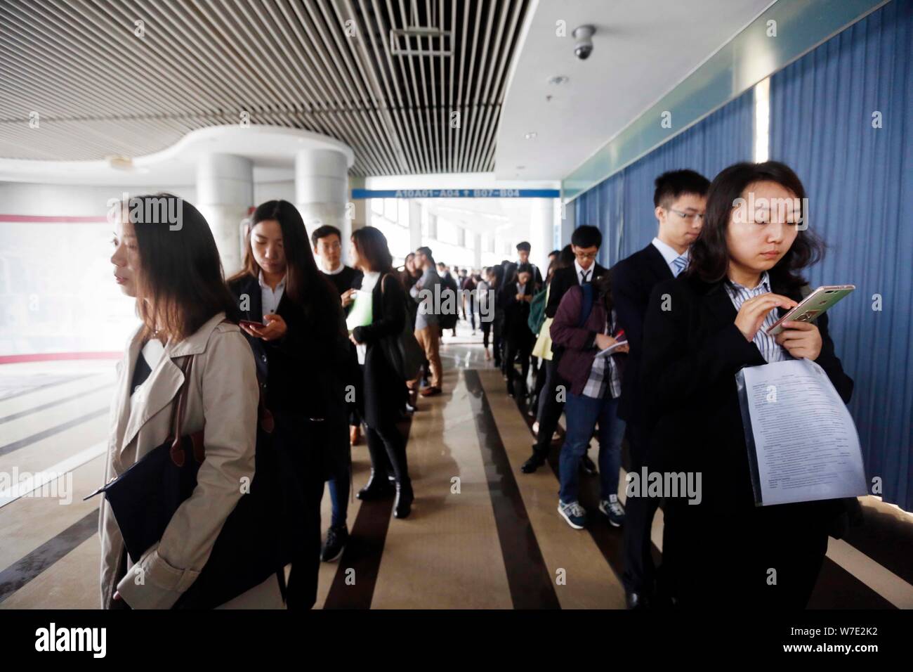 Chinese job seekers queue up to have a talk with interviewers to look for employment in financial sector at a job fair in Shanghai, China, 16 October Stock Photo