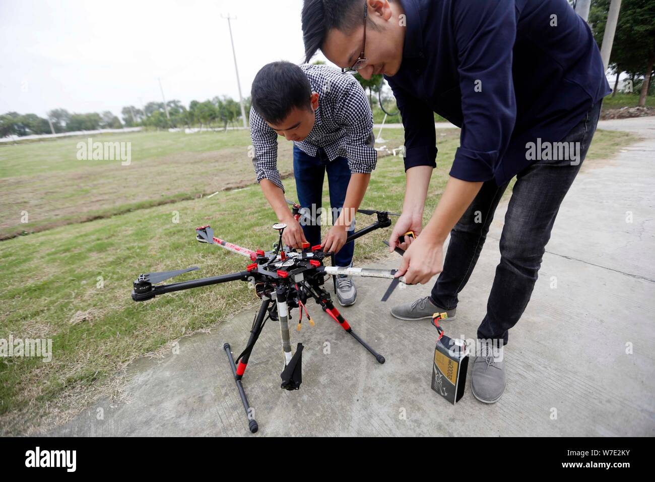 Chinese enthusiasts check a drone, or UAV (unmanned aerial vehicle), at the China's test-flight for civilian drones Civil Aviation Admin Stock Photo -