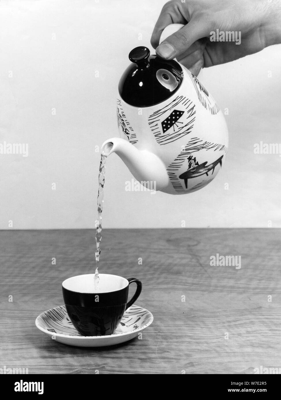 Pouring tea into a cup from a teapot. Artist Unknown Stock Photo Alamy