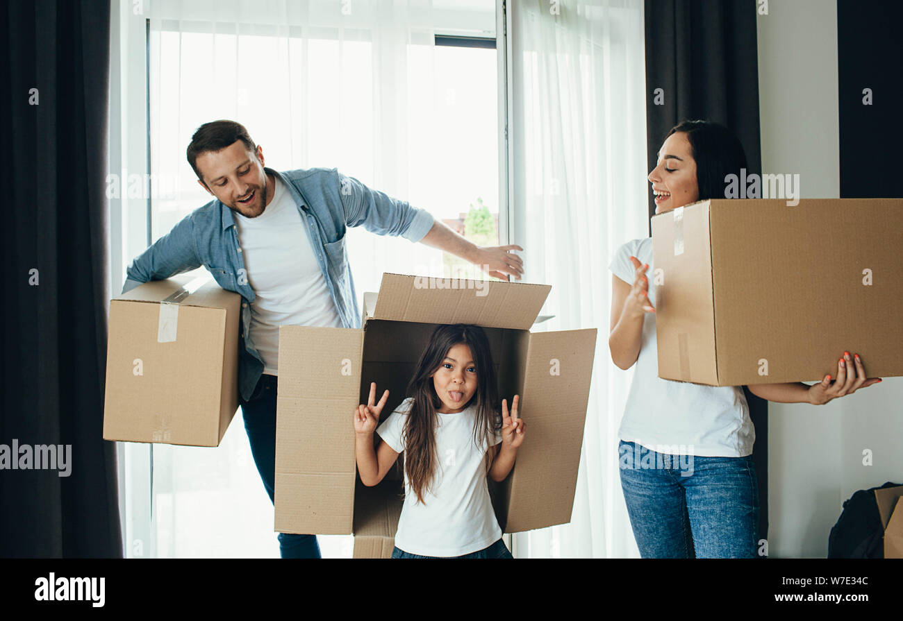 Parents playing with daughter. Family Moving new home Stock Photo