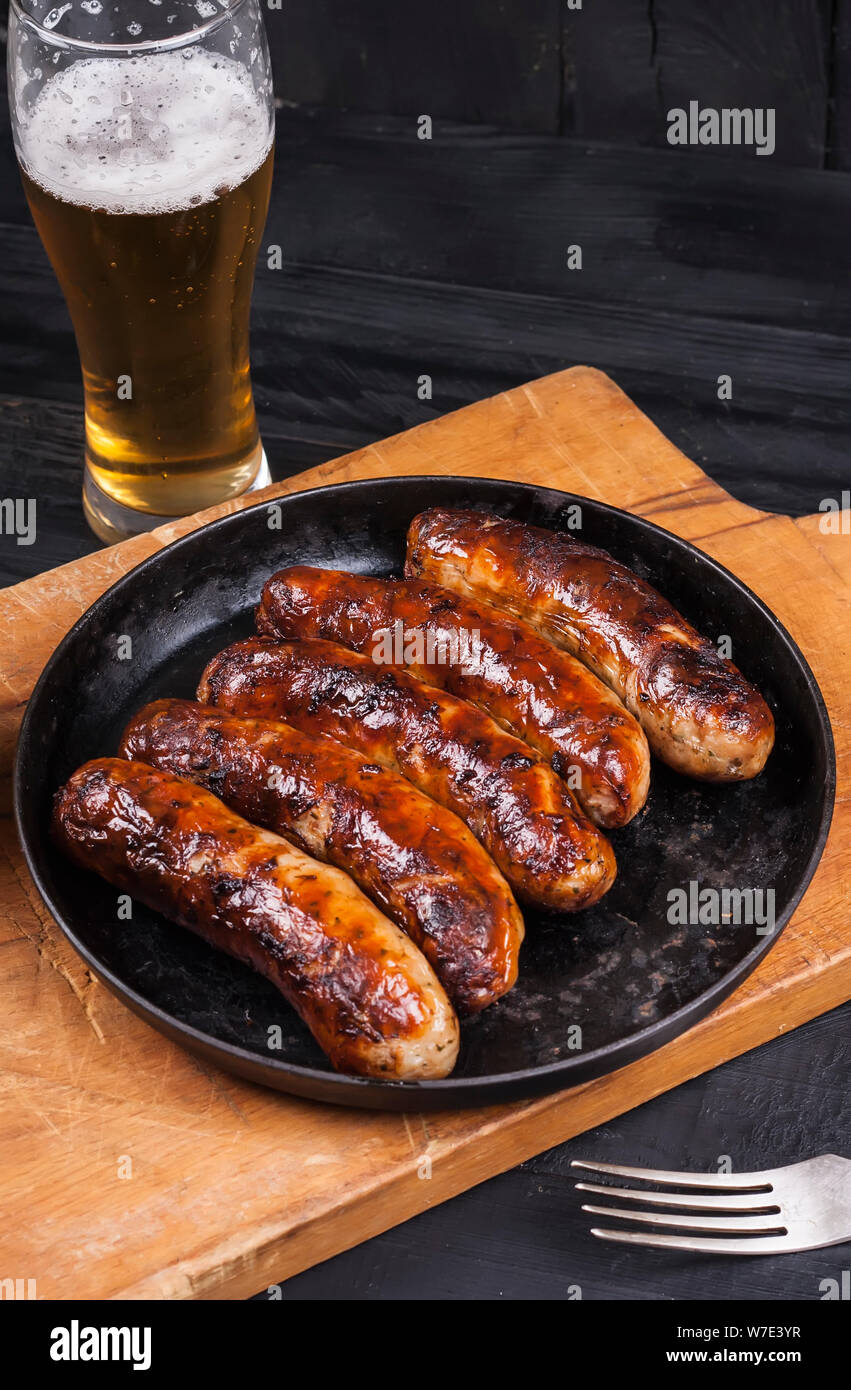 Grilled chicken sausages barbecue on a dark wooden background Stock