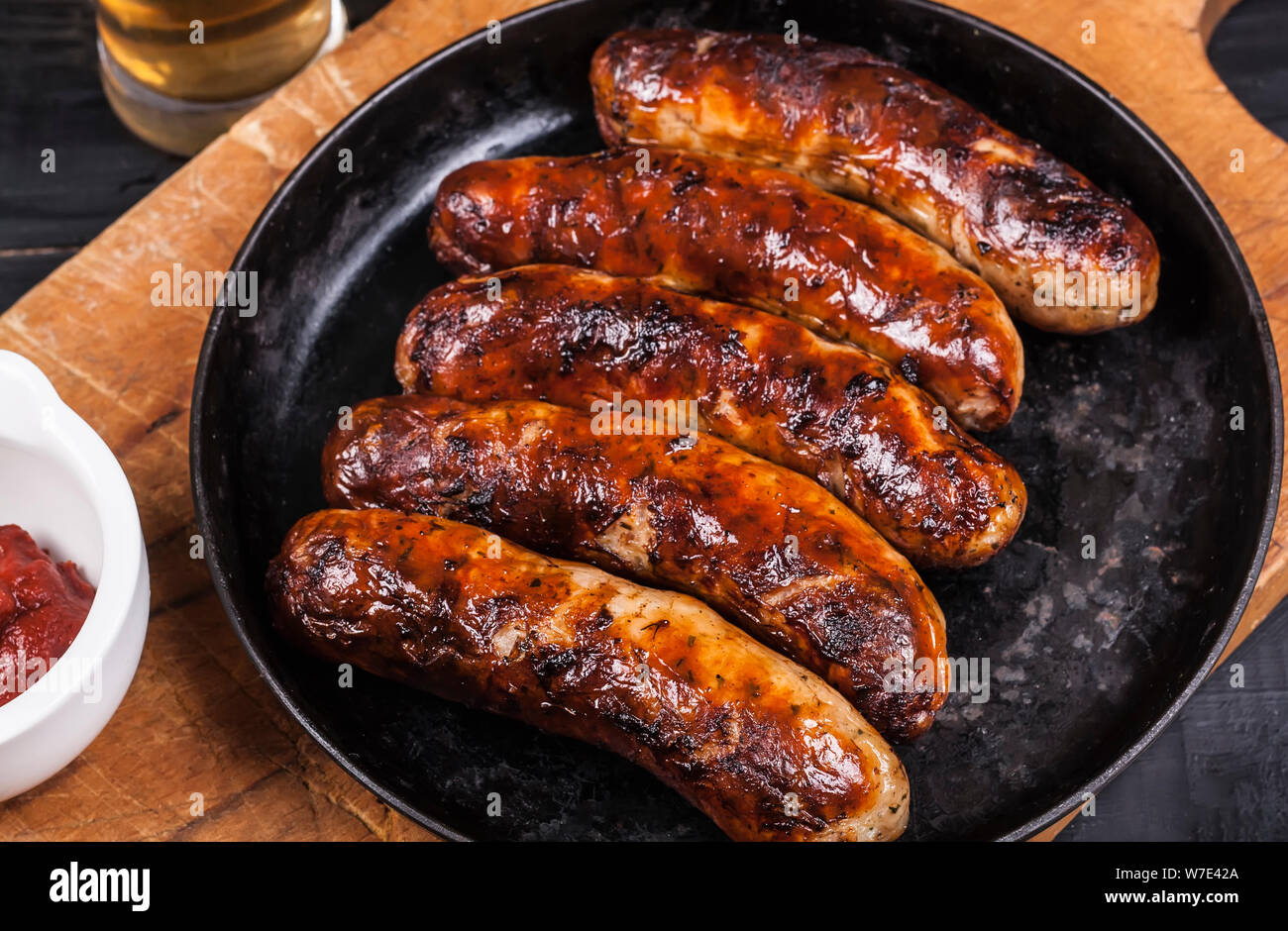 Grilled chicken sausages barbecue on a dark wooden background Stock