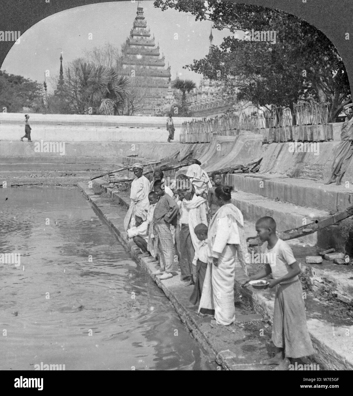 Pilgrims feeding holy turtles, Arakan Pagoda, Mandalay, Burma, 1908.  Artist: Stereo Travel Co Stock Photo