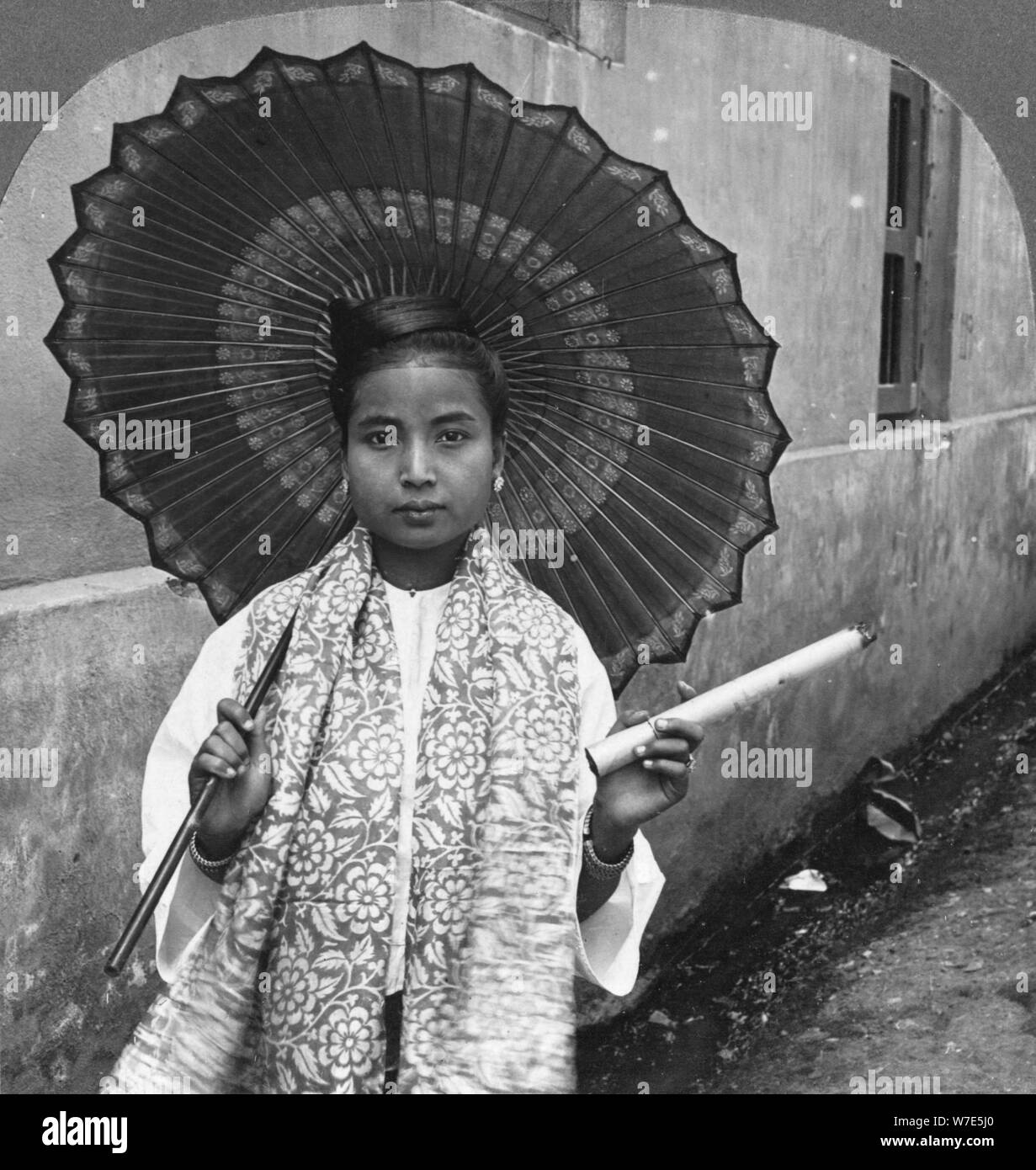 Young Burmese woman holding a huge cigar, Rangoon, Burma, 1908. Artist: Stereo Travel Co Stock Photo
