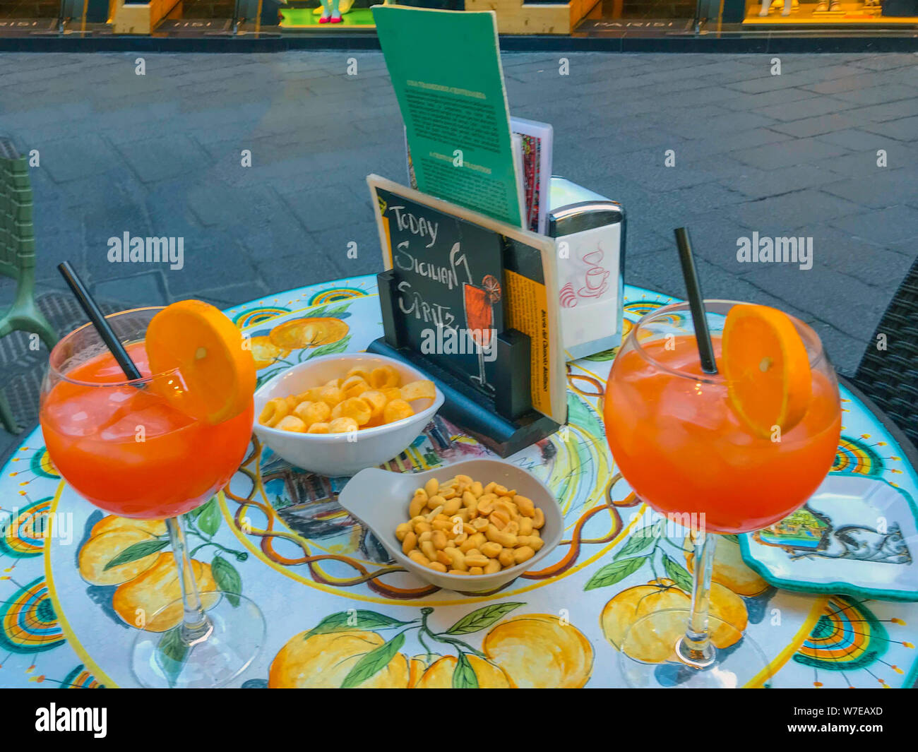 Palermo Sicily Italy  June 25, 2018:  Two glasses Aperol spritz cocktail  on a ceramic table in a street cafe in Italy. Stock Photo