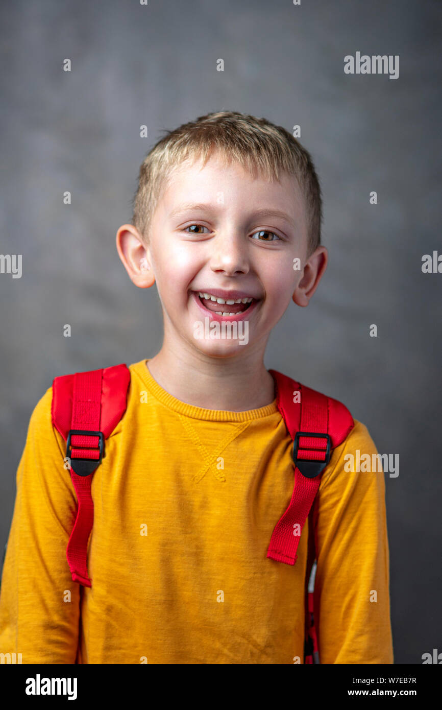 portrait of a happy and carefree 6-year-old student with a backpack on his shoulders. Stock Photo