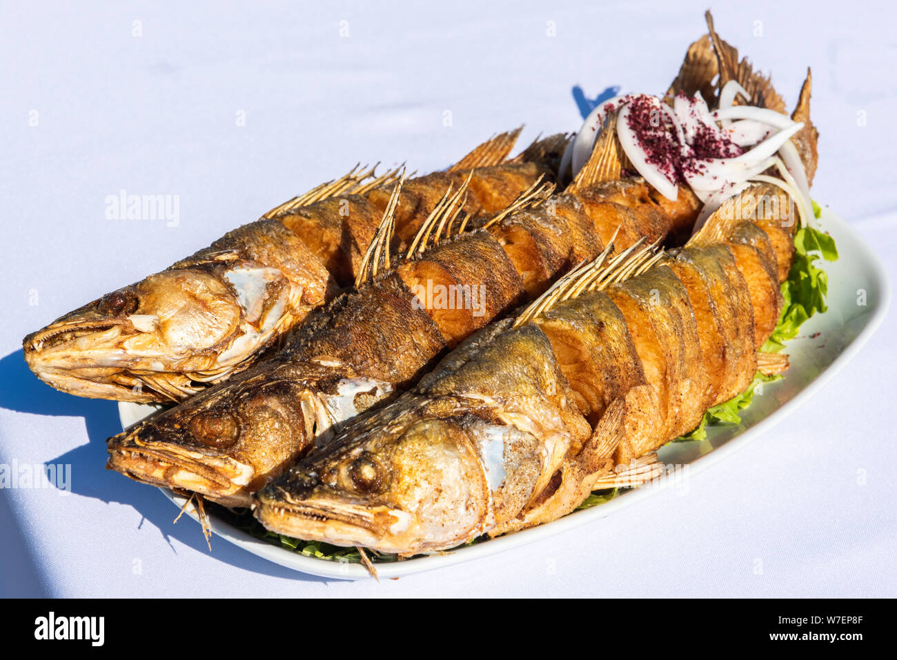 Plate with three pike-perch fish served in a fishing restaurant in Bibi-Heybat settlement of Baku, Azerbaijan. Stock Photo