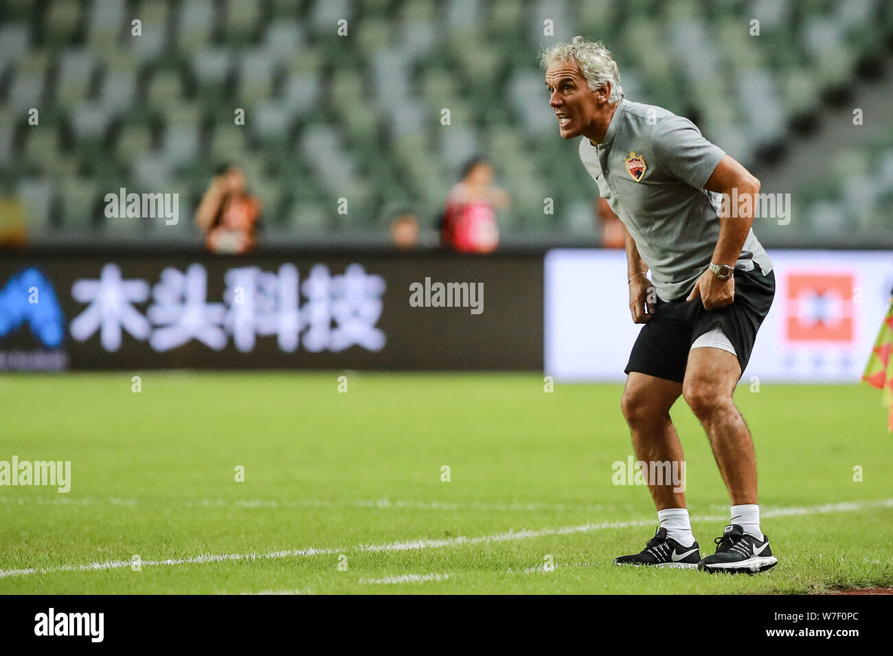 Head coach Roberto Donadoni of Shenzhen F.C. reacts as he watches his players competing against Beijing Renhe in their 21st round match during the 2019 Chinese Football Association Super League (CSL) in Shenzhen city, south China's Guangdong province, 2 August 2019. Shenzhen F.C. played draw to Beijing Renhe 1-1. Stock Photo