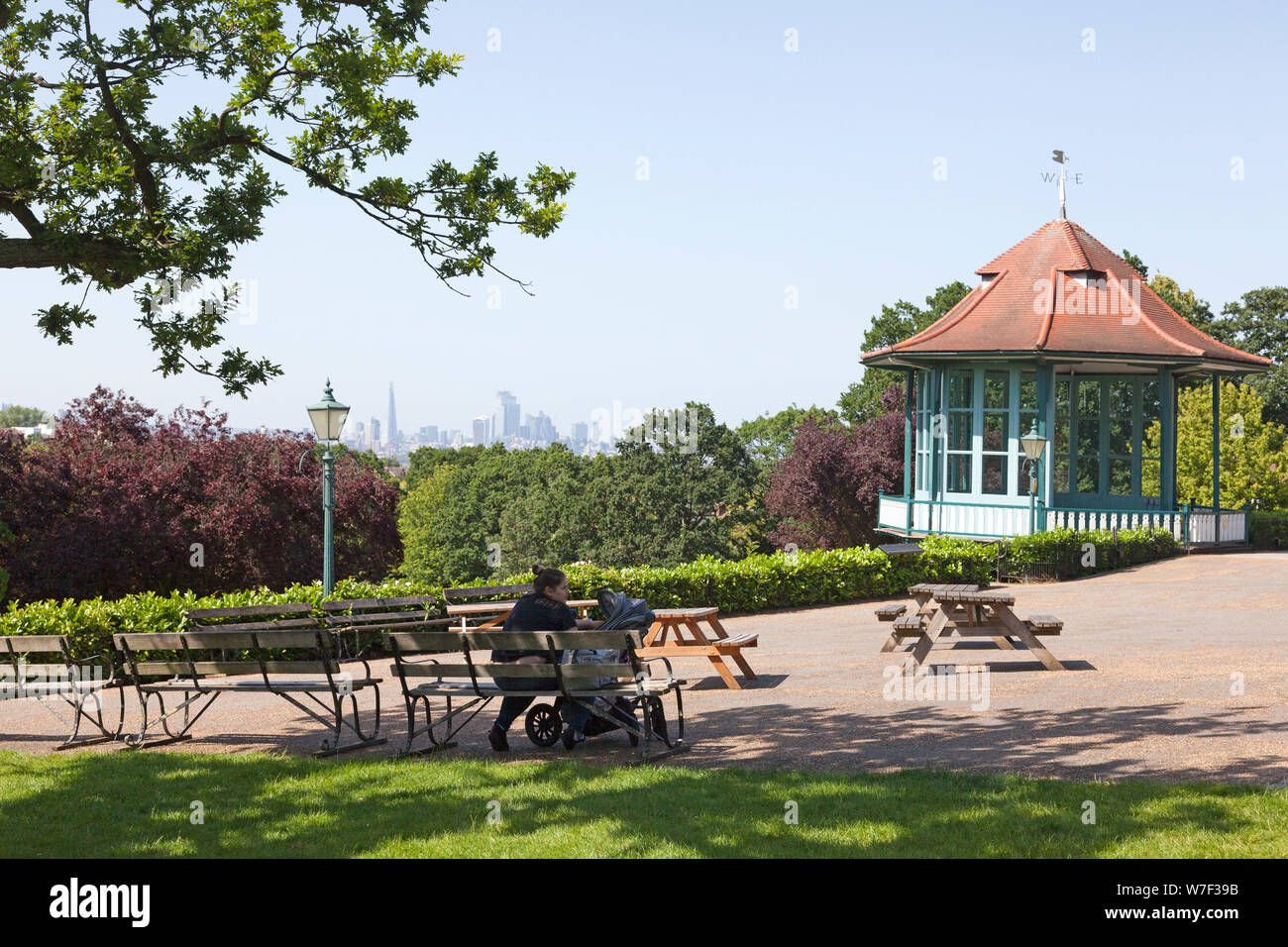 Woman with buggy sitting beside the Victorian Bandstand at Horniman Gardens, Forest Hill, London Stock Photo
