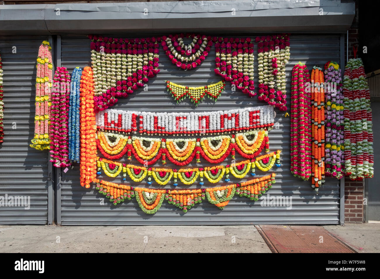 Colorful strings of garlands outside a closed store that sells clothing and Hindu religious articles. In Richmond Hill, Queens, New York City. Stock Photo
