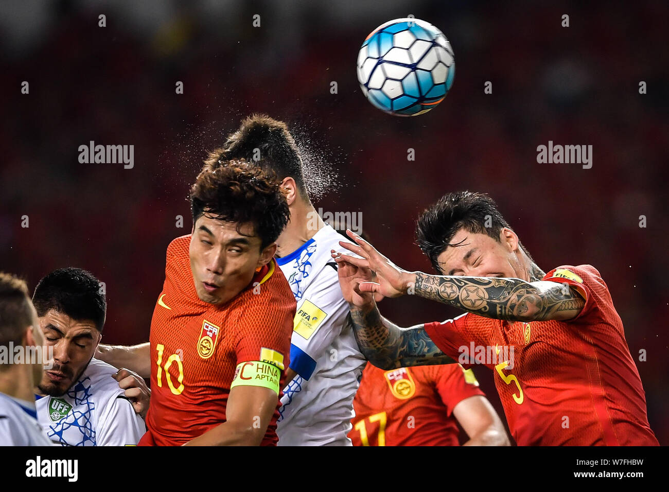Zheng Zhi, left, and Zhang Linpeng, right, of China head the ball against a player of Uzbekistan in their Group A Round 9 match during the 2018 FIFA W Stock Photo