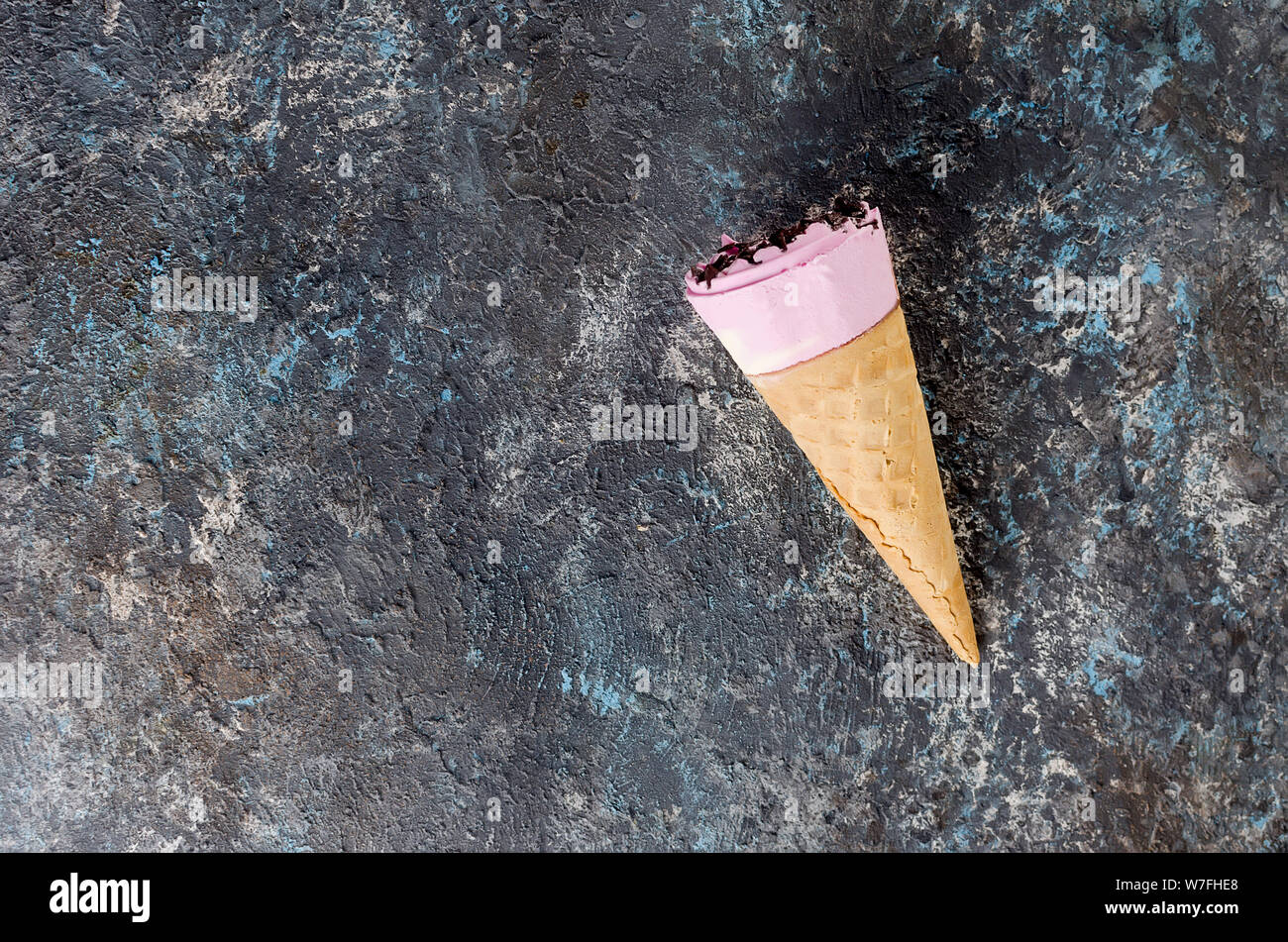 https://c8.alamy.com/comp/W7FHE8/close-up-of-ice-cream-in-wafer-cone-with-chocolate-topping-on-a-dark-concrete-background-top-view-W7FHE8.jpg