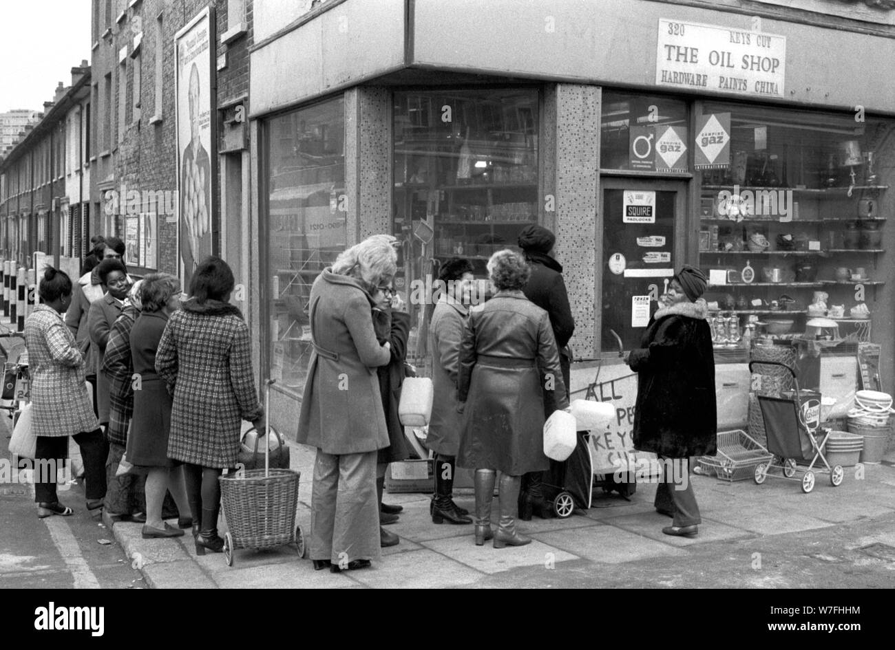 Fuel shortage 1970s UK. People queuing up to buy oil and paraffin from a corner shop The Oil Shop, so as to be able to heat their  homes south London. December 1974 England. HOMER SYKES Stock Photo