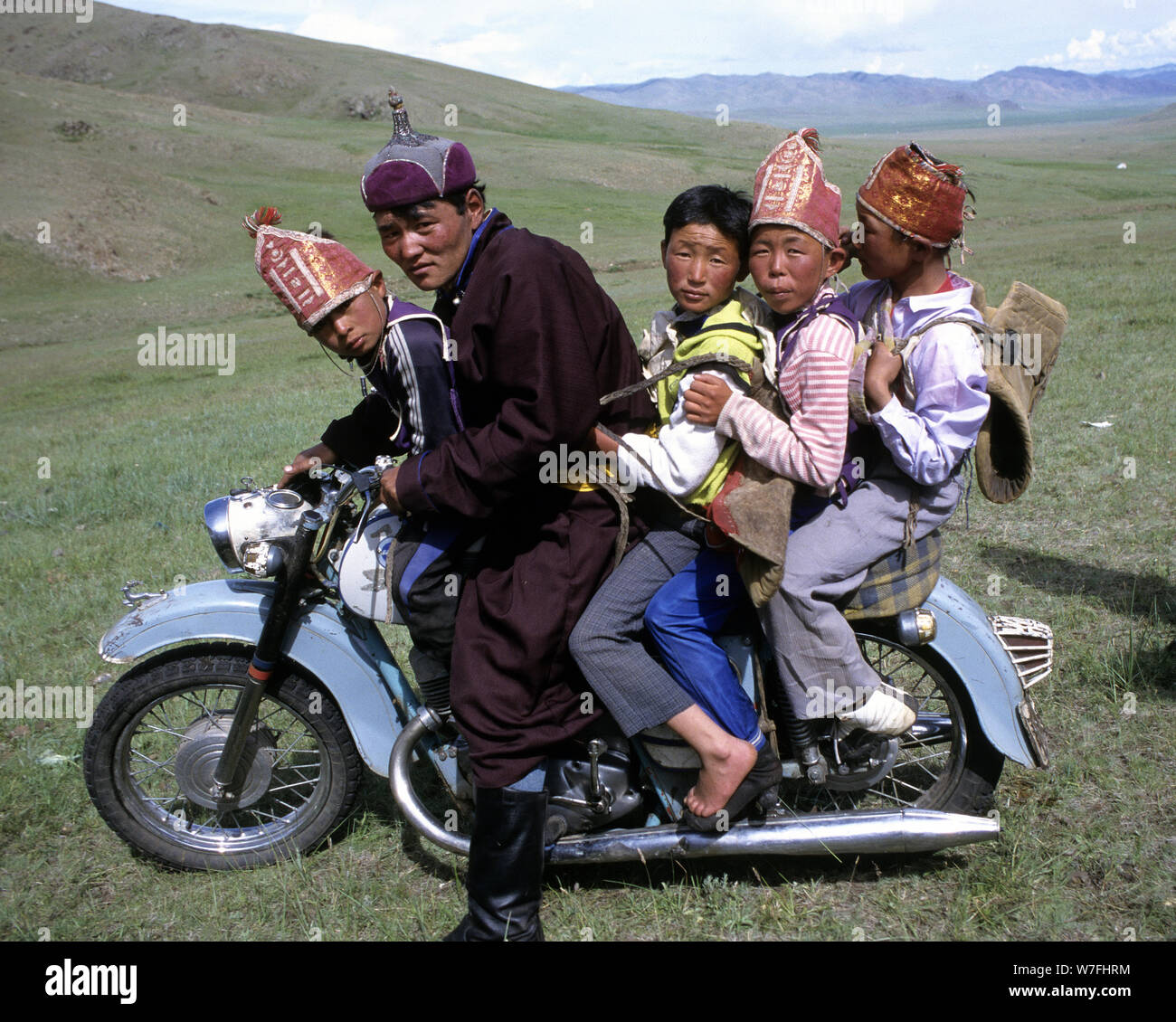 5 Mongolians riding a motorbike during the Nadaam festival Stock Photo
