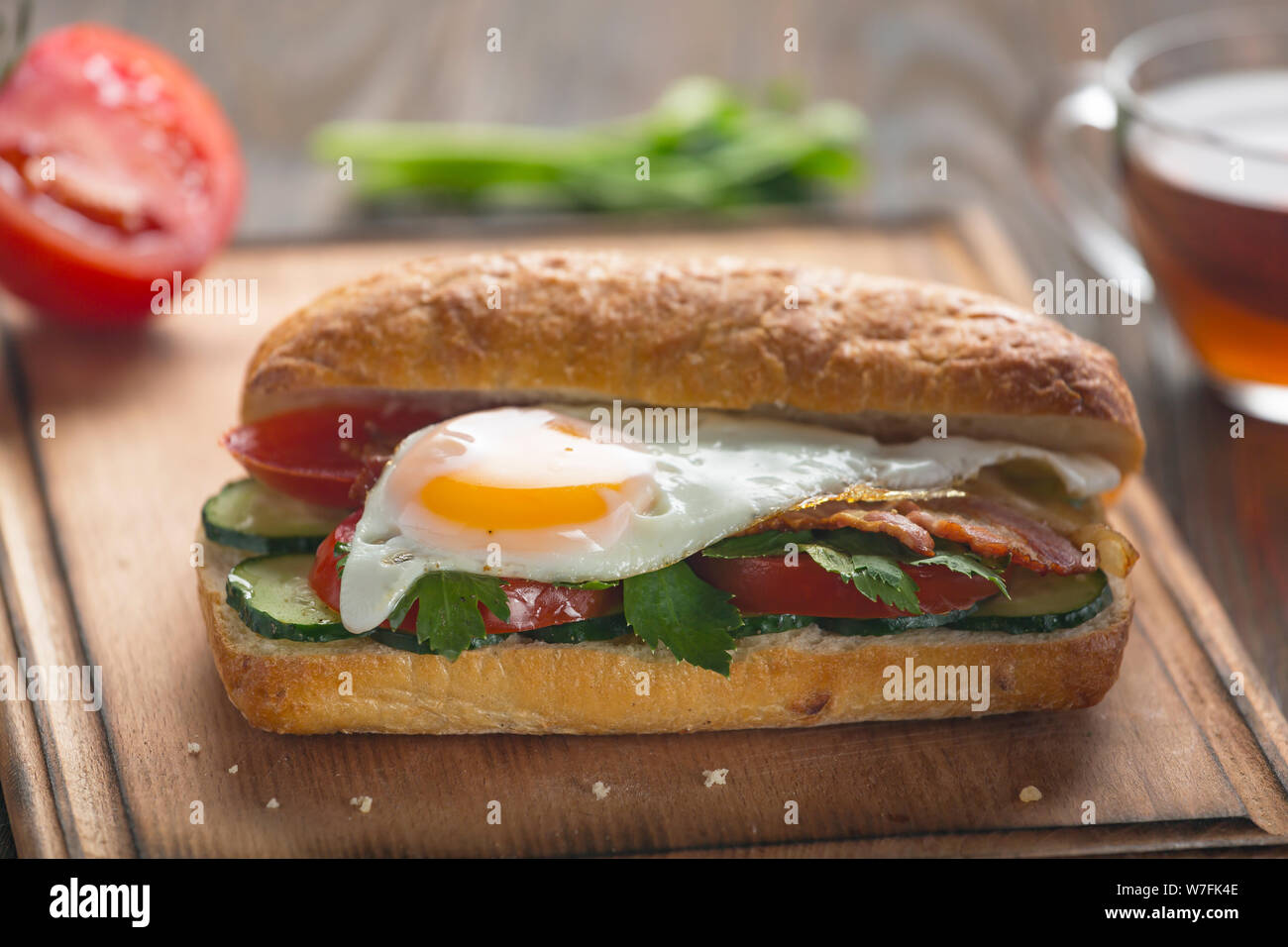 Sandwich with egg, bacon, vegetables and herbs Stock Photo