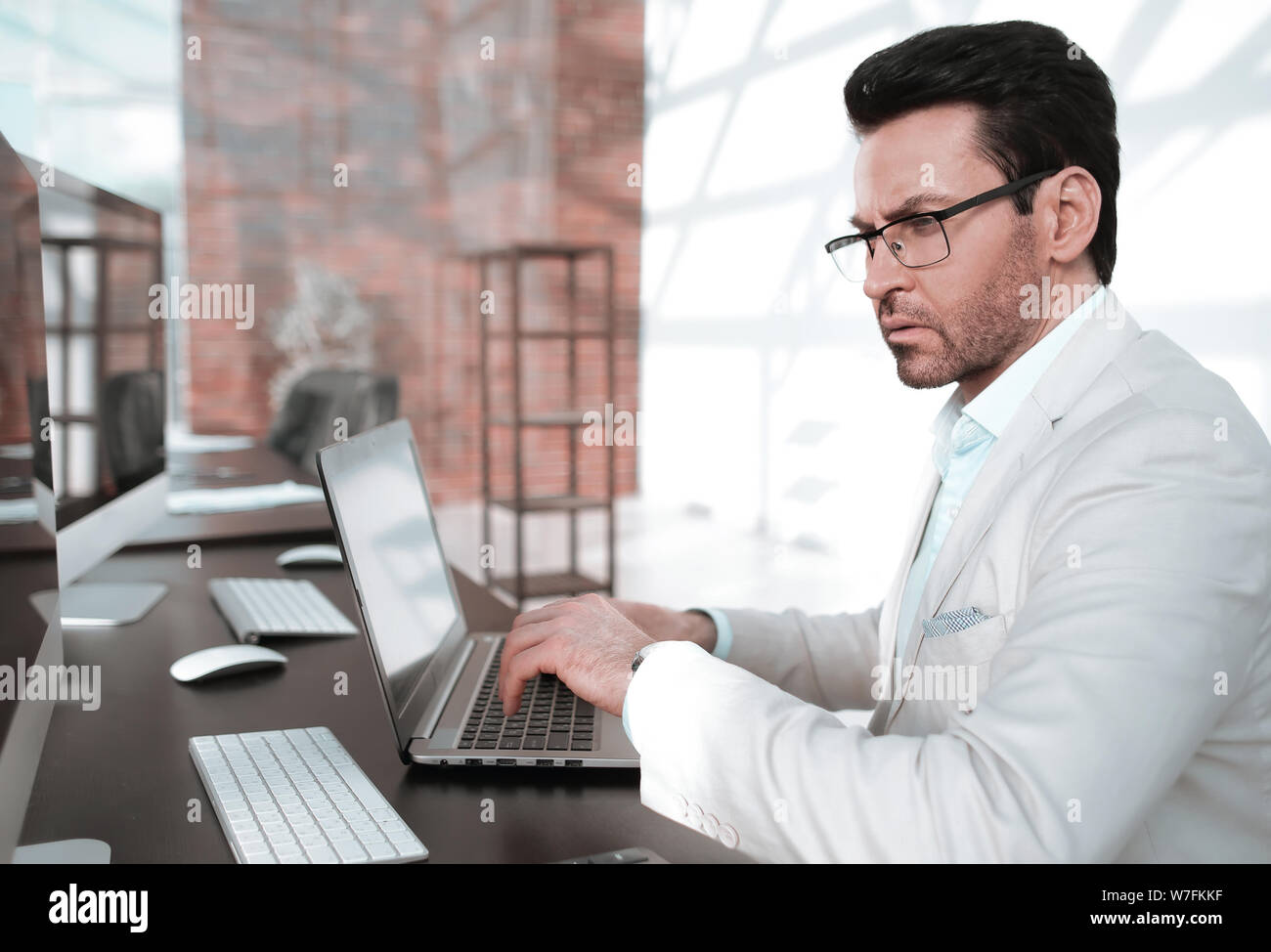 behind the glass.serious businessman typing on a laptop Stock Photo - Alamy