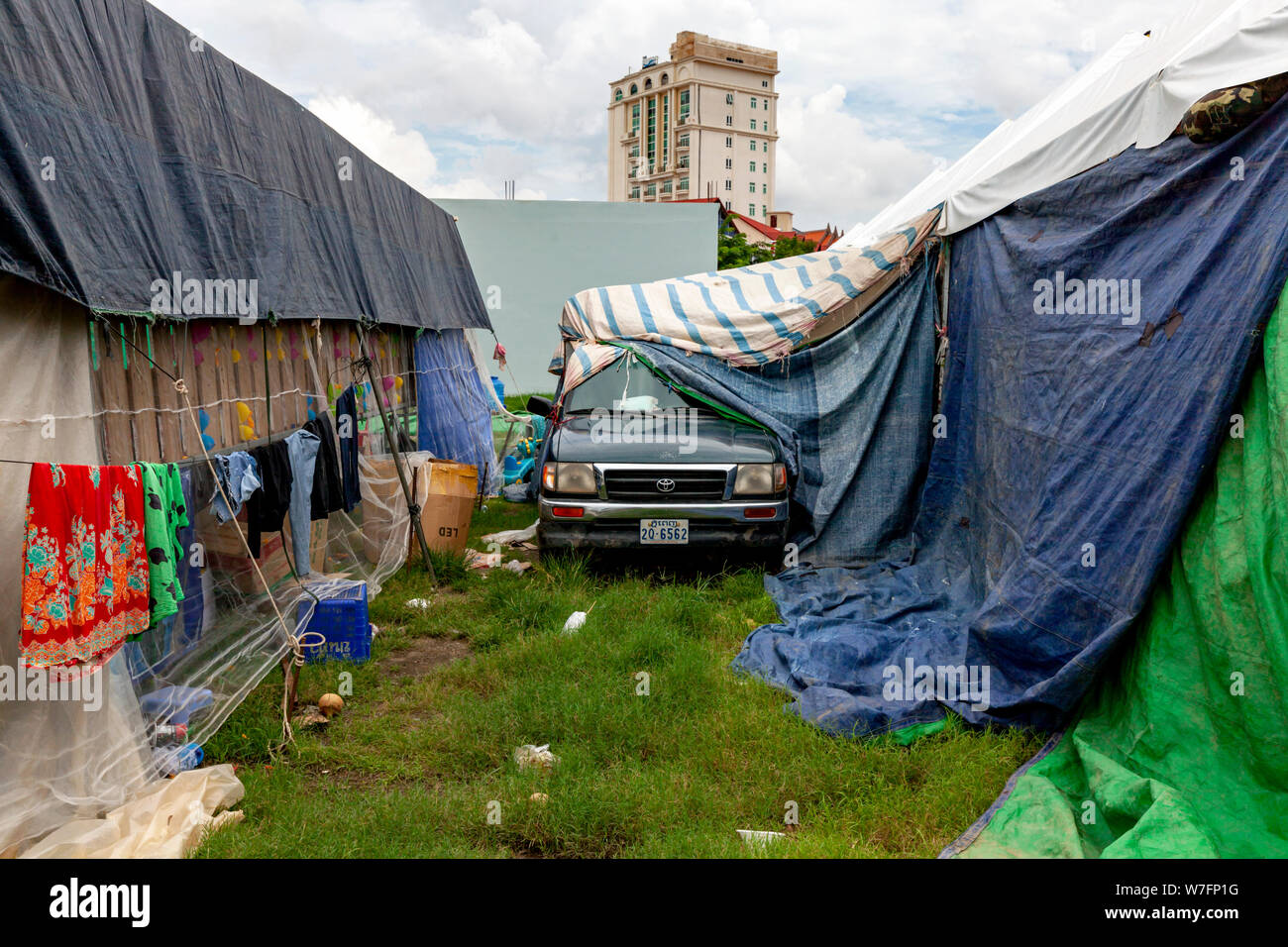 A truck is parked between the back of carnival game stalls that are covered with tarps on a normally empty piece of land in Kampong Cham, Cambodia. Stock Photo