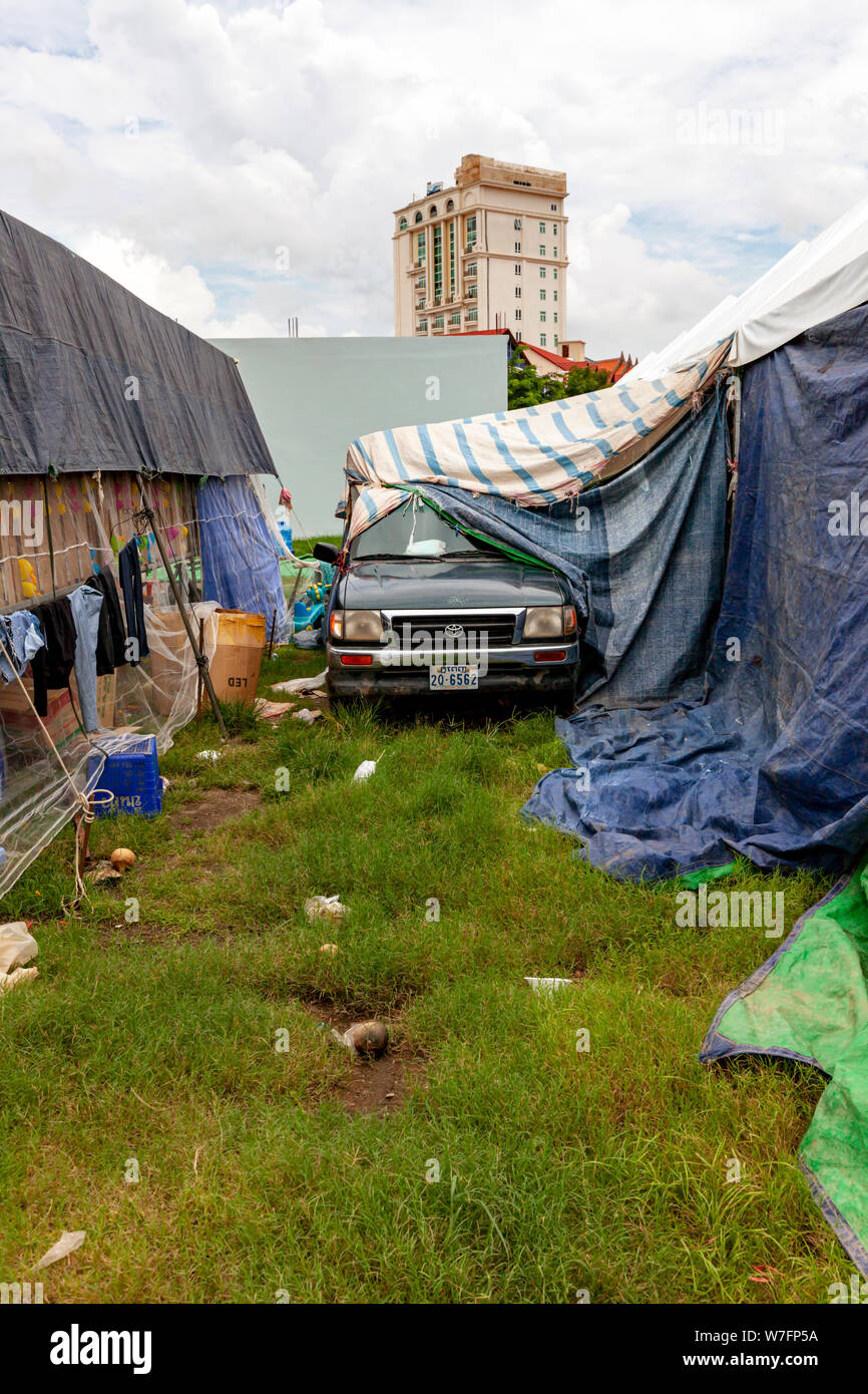 A truck is parked between the back of carnival game stalls that are covered with tarps on a normally empty piece of land in Kampong Cham, Cambodia. Stock Photo