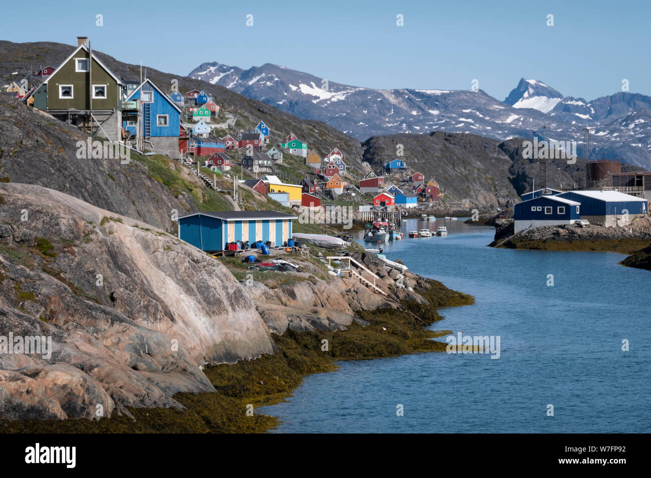 Traditional colored houses of the isolated village Kangaamiut in western Greenlanc in a wonderful natural setting with mountains in the background. Stock Photo
