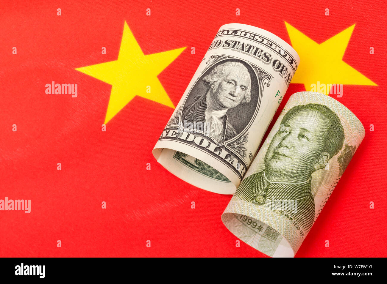 Chinese Yuan Renminbi banknote + U.S One Dollar bill & China flag. For Trump's reference China currency manipulation, trade war falling yuan Stock Photo