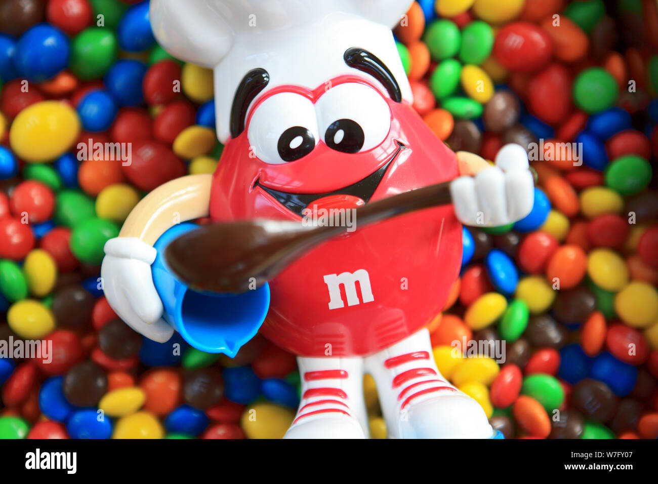 M&M's red candy dispenser of a chef with mixing bowl & spoon on top of a  pile of M&Ms colourful candy-coated chocolates Stock Photo - Alamy