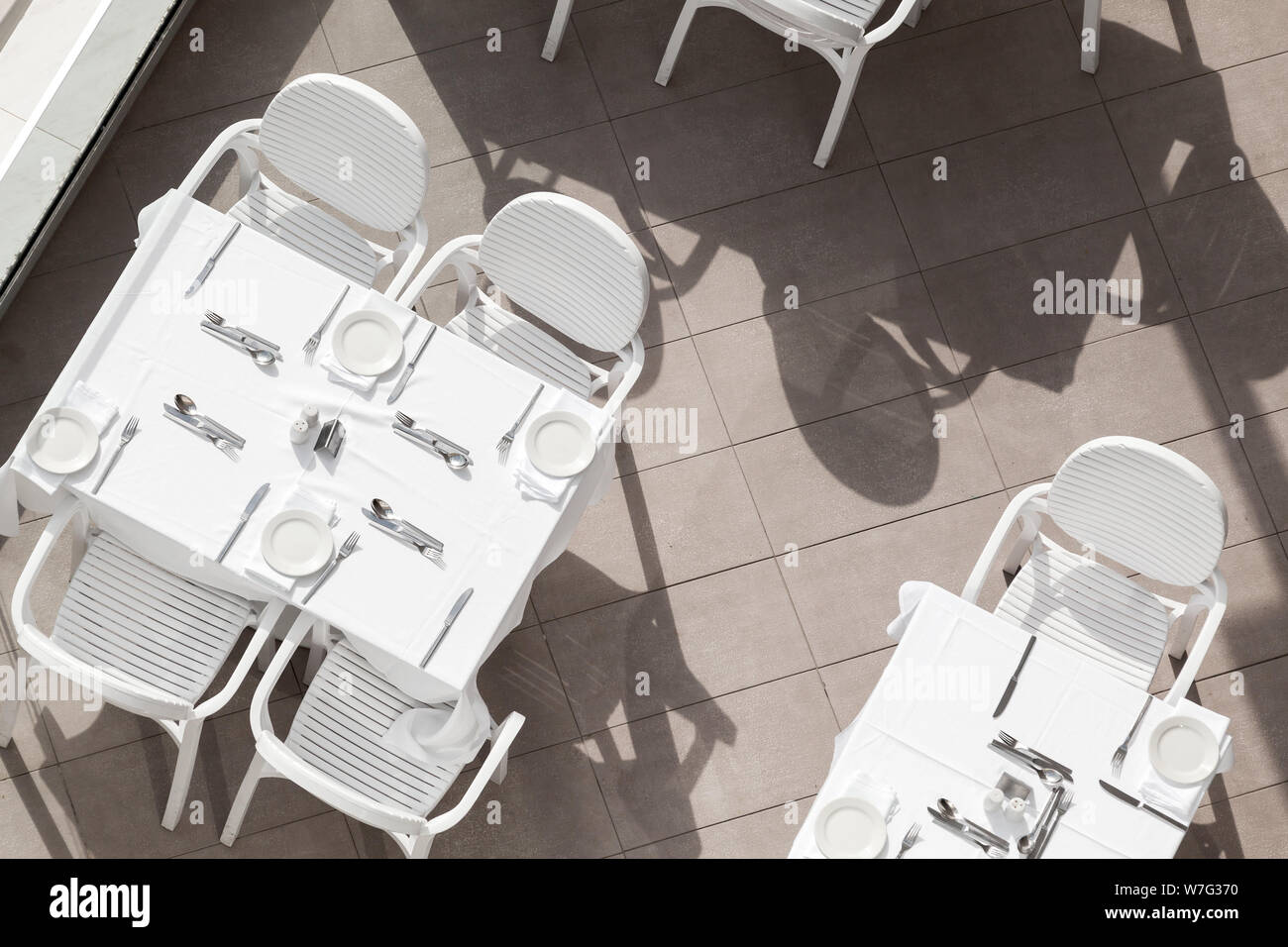 White Tables And Chairs Stand At An Empty Outdoor Terrace Top