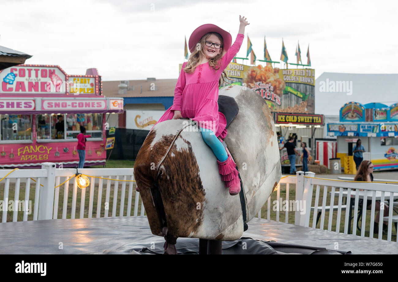 Annabelle Davis gets a taste of mechanical-bull riding at Rodeo Austin, the city's annual stock show and rodeo. Austin, Texas Stock Photo