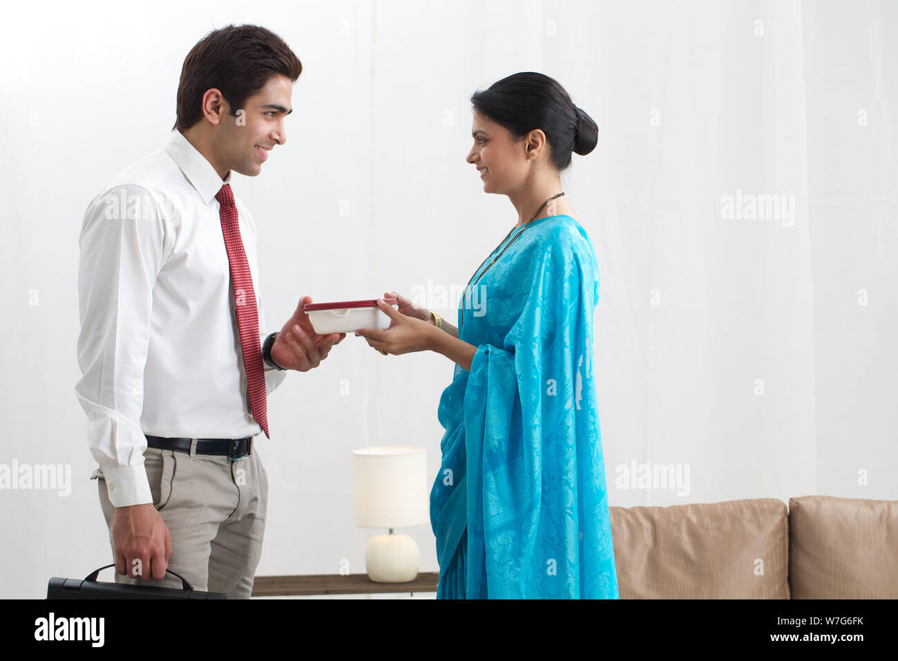 Young woman giving office lunch to her husband Stock Photo Alamy