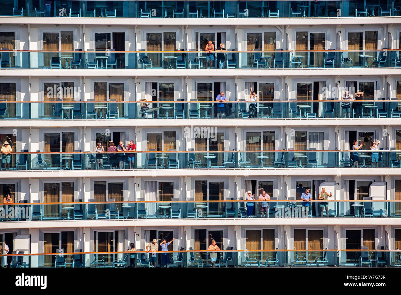 Close up of row upon row of port side Cruise Ship cabin balconies some with passengers at the dock in Tallinn, Estonia on 21 July 2019 Stock Photo