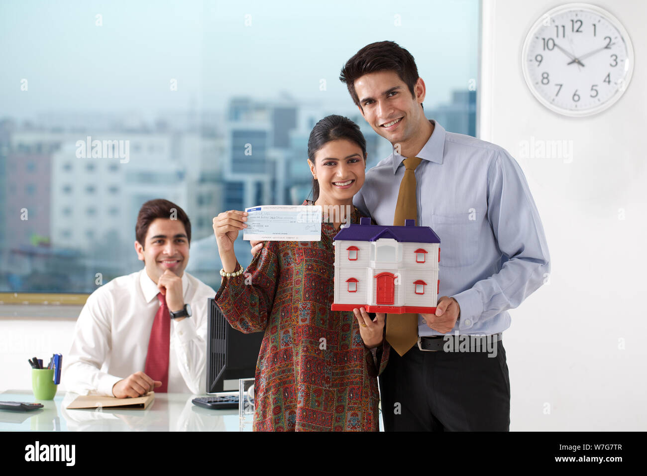 Young couple showing cheque and dream home Stock Photo - Alamy