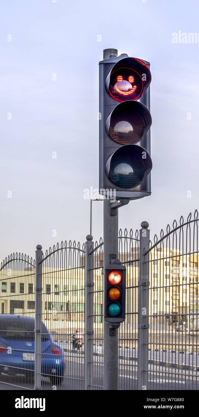 Unusual signal: A red smiley, a happy laughing face on the traffic light stops the traffic at this arterial road in Adschman (United Arab Emirates).  (14 January 2019) | usage worldwide Stock Photo