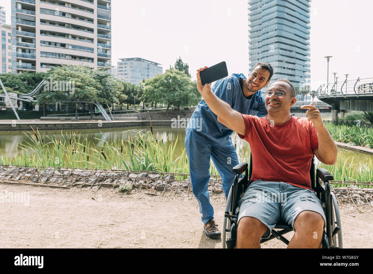 disabled man in a wheelchair taking a selfie with his caretaker during ...