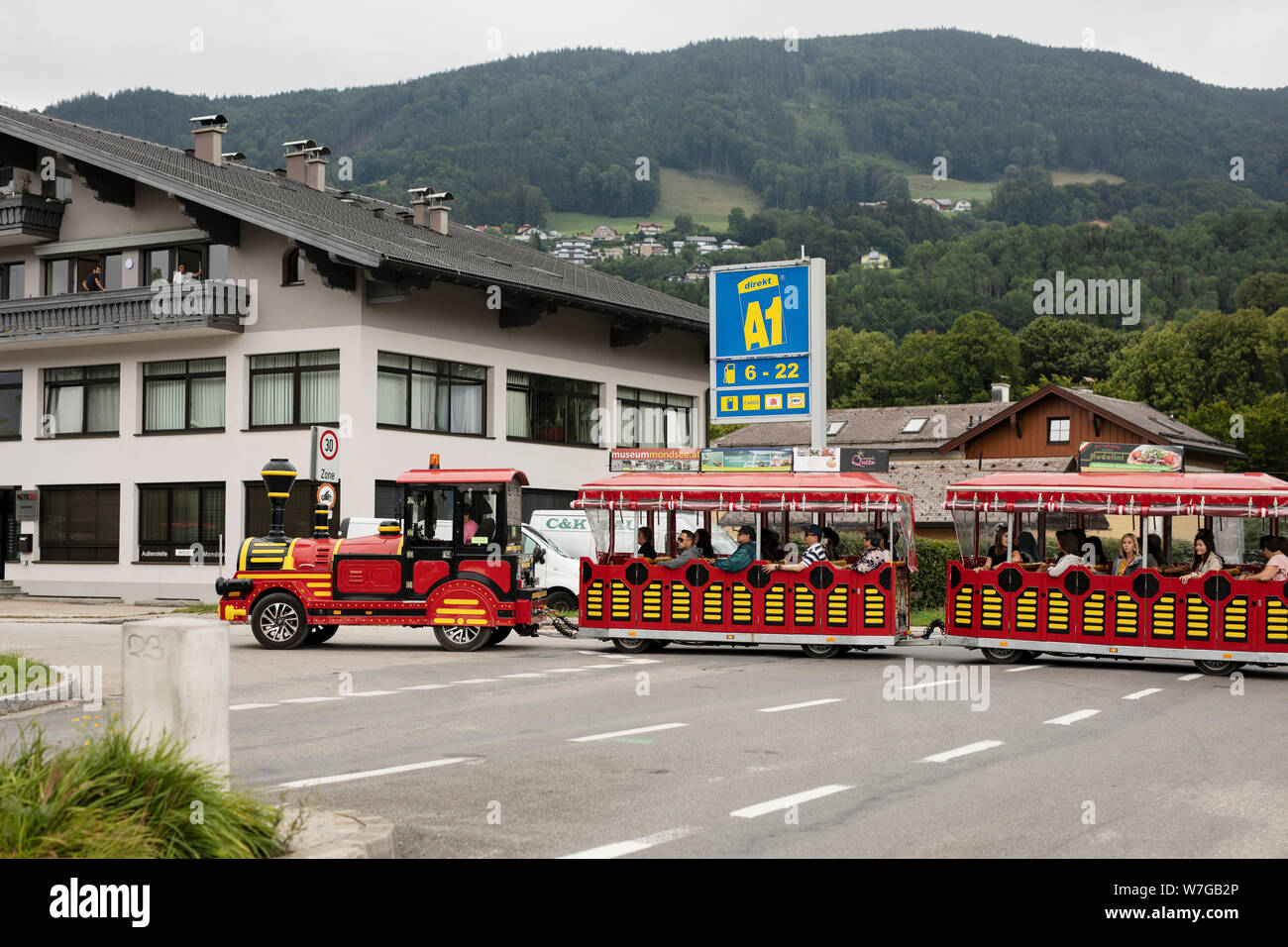 A tourist trolley transports visitors from parking lots to the center of the Alpine town of Mondsee, Austria. Stock Photo