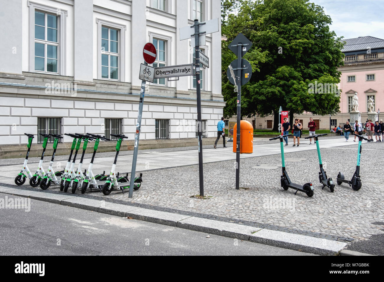 Lime & Tier E-scooters on city pavement near Green Bebelplatz in tourist area, Unter den Linden, Mitte,Berlin.Rival Companies compete for space on city pavements Stock Photo