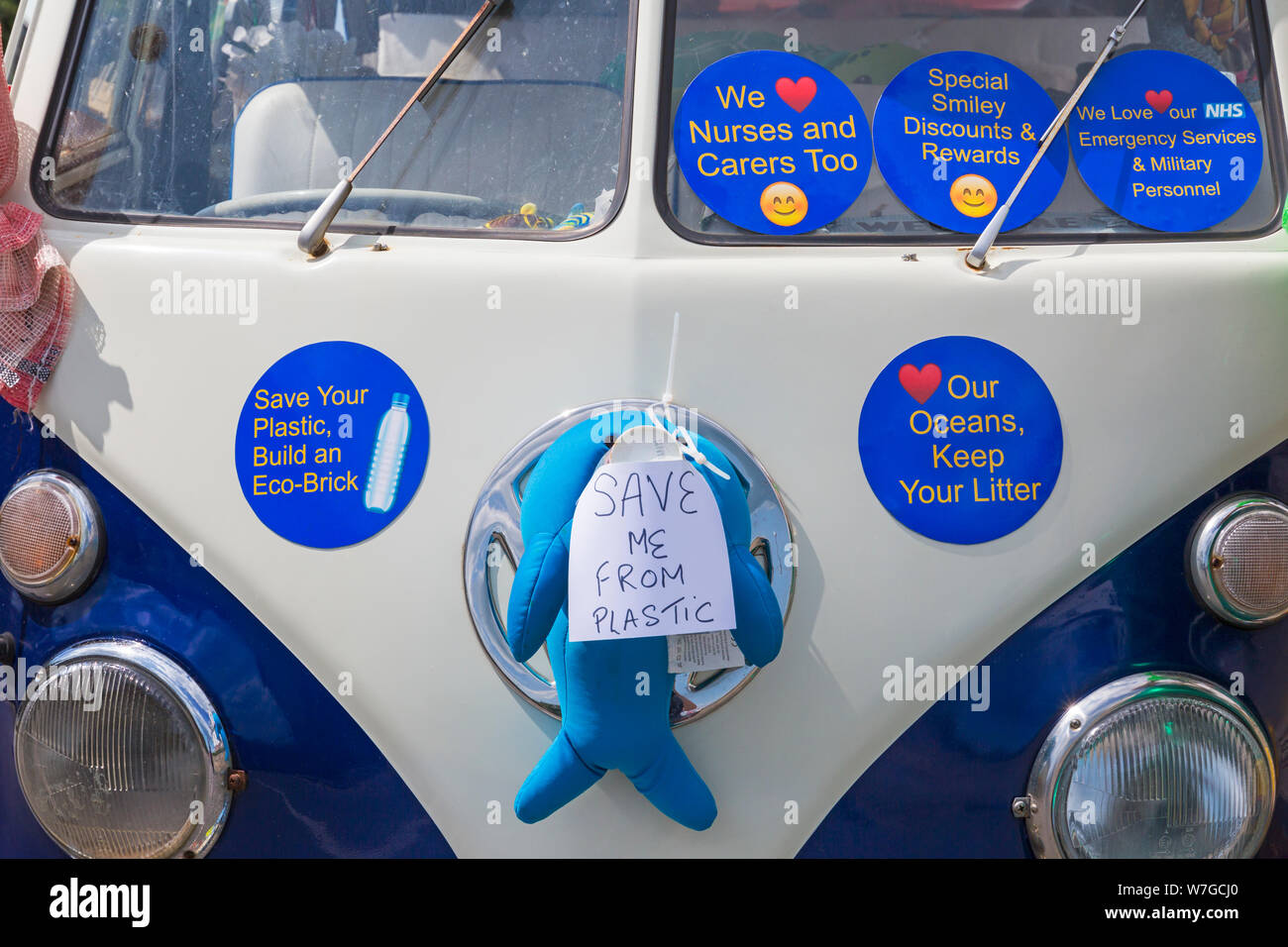Save me from plastic and stickers with messages on decorated campervan taking part in Swanage carnival parade procession at Swanage, Dorset UK in July Stock Photo