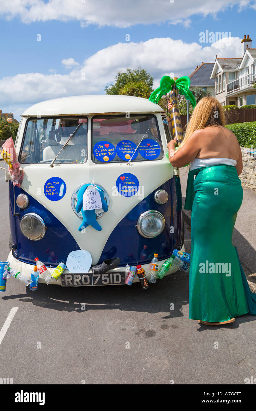 Save me from plastic and stickers with messages on decorated campervan taking part in Swanage carnival parade procession at Swanage, Dorset UK in July Stock Photo