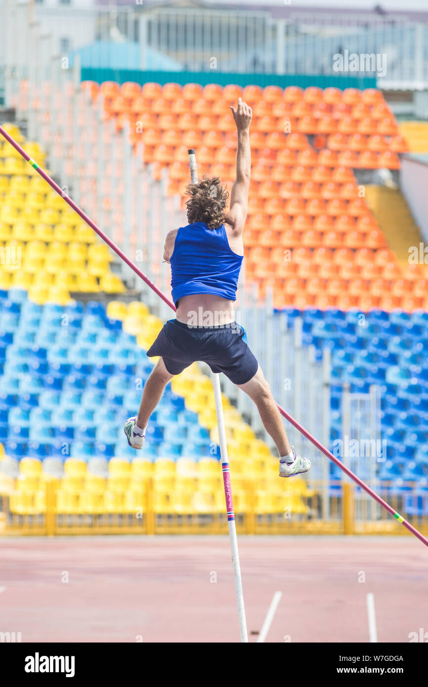 Pole vault an athletic man jumping over the bar Stock Photo Alamy