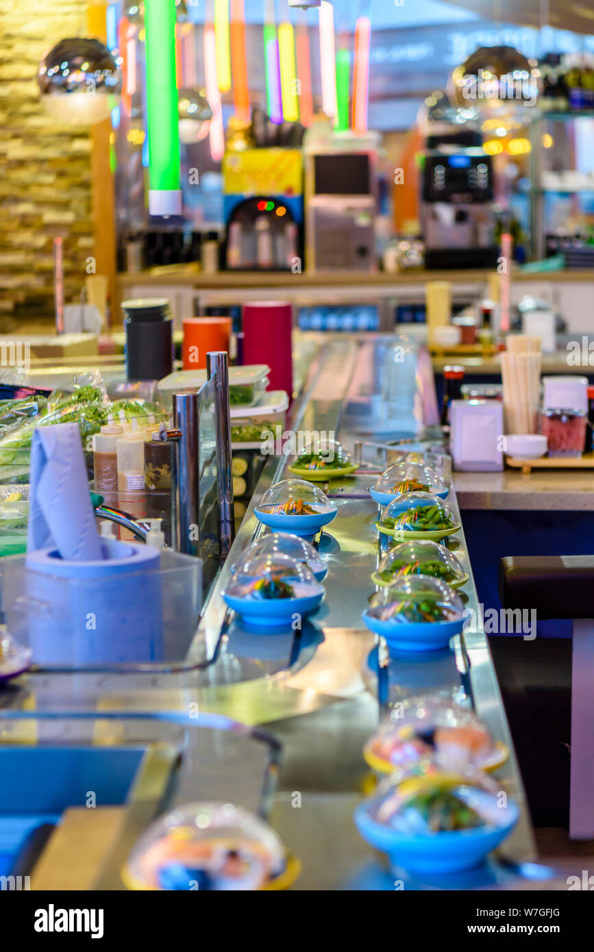 Bowls of sushi on a conveyor belt at a branch of Yo! Sushi. Stock Photo