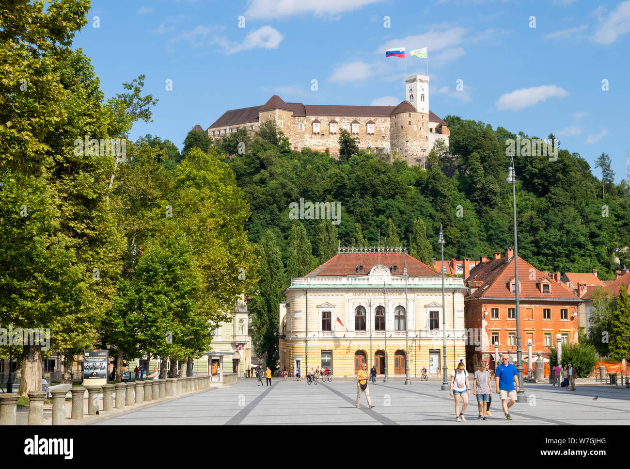 ljubljana castle with slovenian flag flying behind the Slovenian Philharmonic building Congress square Ljubljana Slovenia EU Europe Stock Photo