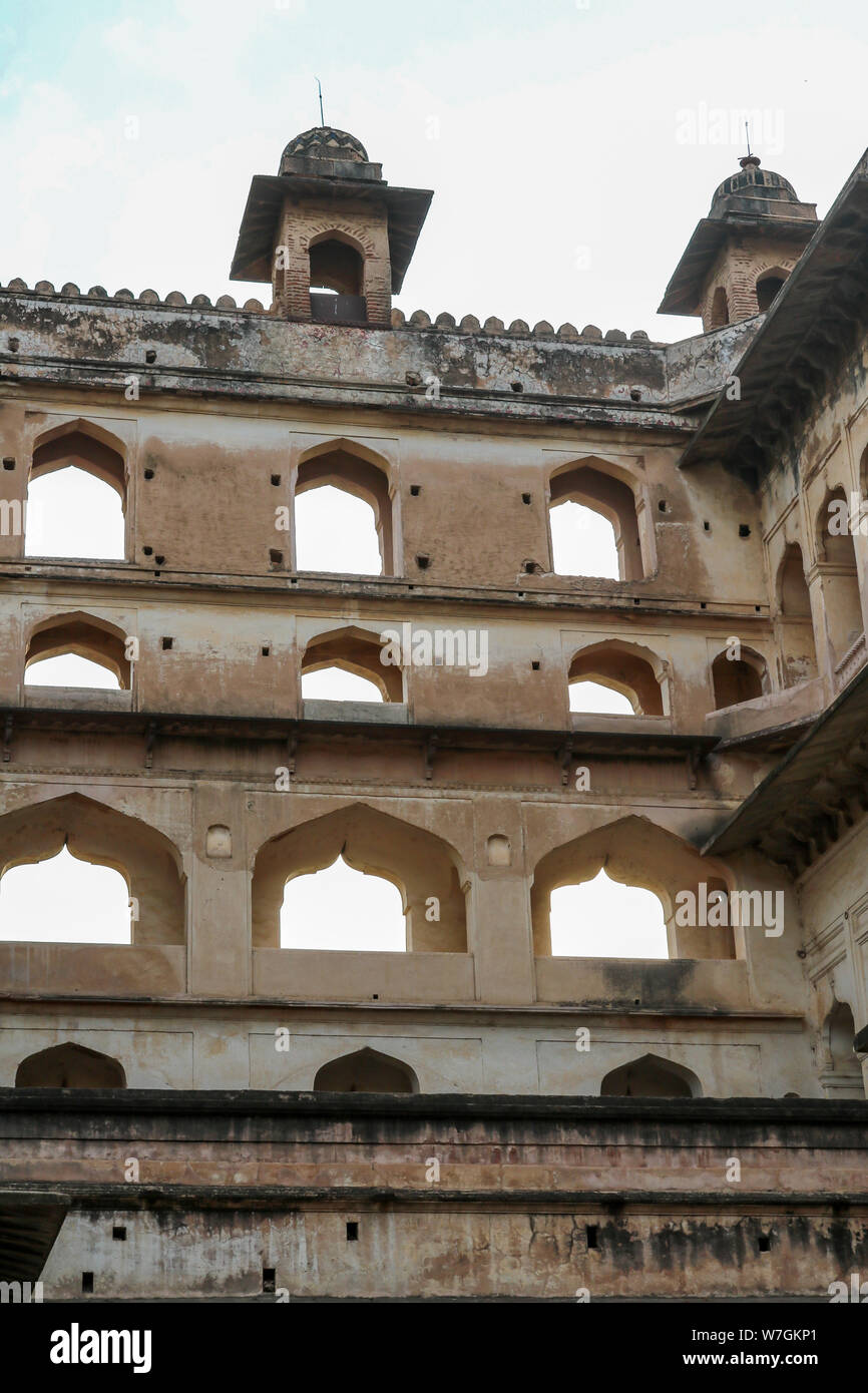 Facade, open windows and decorated dome roofs of the Orchha Palace in