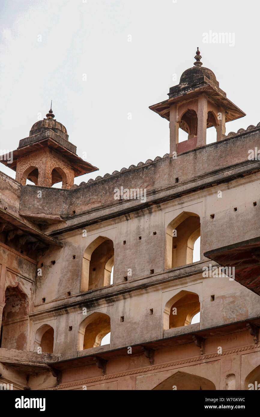 Facade, open windows and decorated dome roofs of the Orchha Palace in