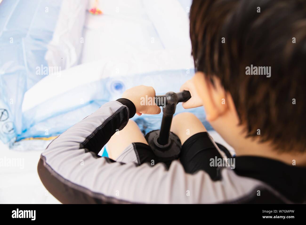 People are pumping big rubber toy pool - family lifestyle play at home concept Stock Photo