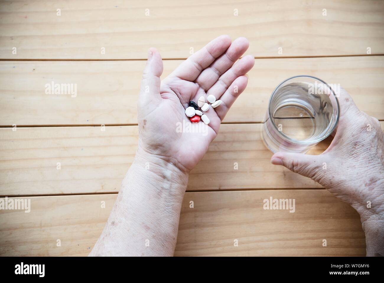 Old lady prepare to eat daily medicine pill - people healthcare with medicine pills concept Stock Photo