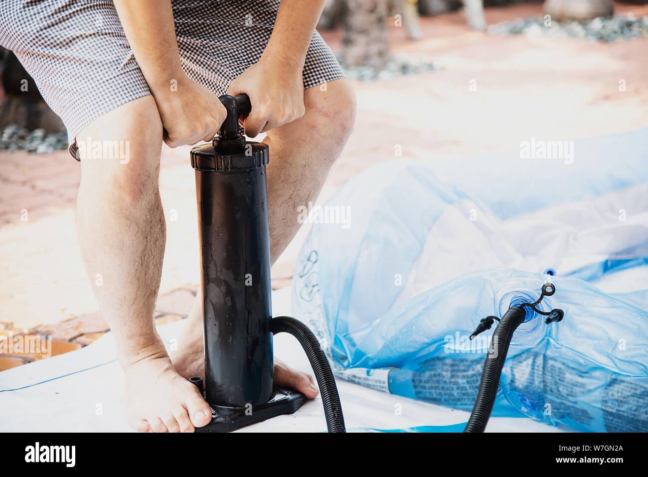 People are pumping big rubber toy pool - family lifestyle play at home concept Stock Photo