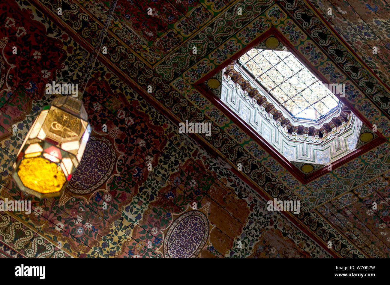 Painted wooden ceiling, with an opening to the outside. Bahia Palace, Marrakech. Stock Photo
