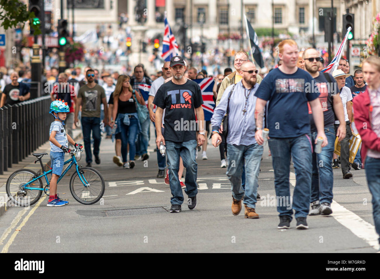 Protesters in Whitehall at Free Tommy Robinson protest rally In London, UK. They blocked the RideLondon Freecycle cycling event. Boy cyclist bemused Stock Photo