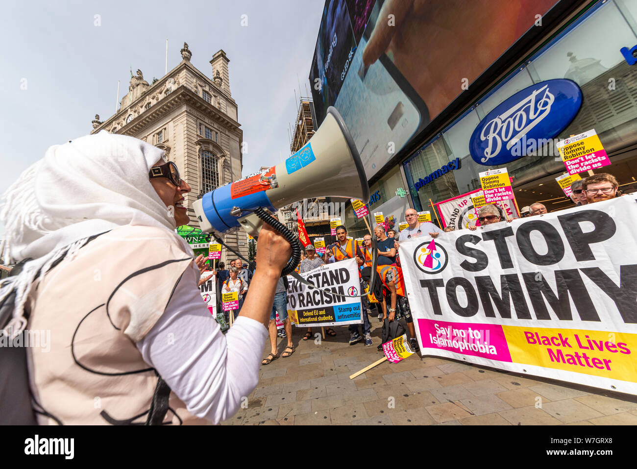 Anti Fascist protesters in opposition at Free Tommy Robinson protest rally In London, UK. Female Muslim chanting through a loud hailer, megaphone Stock Photo