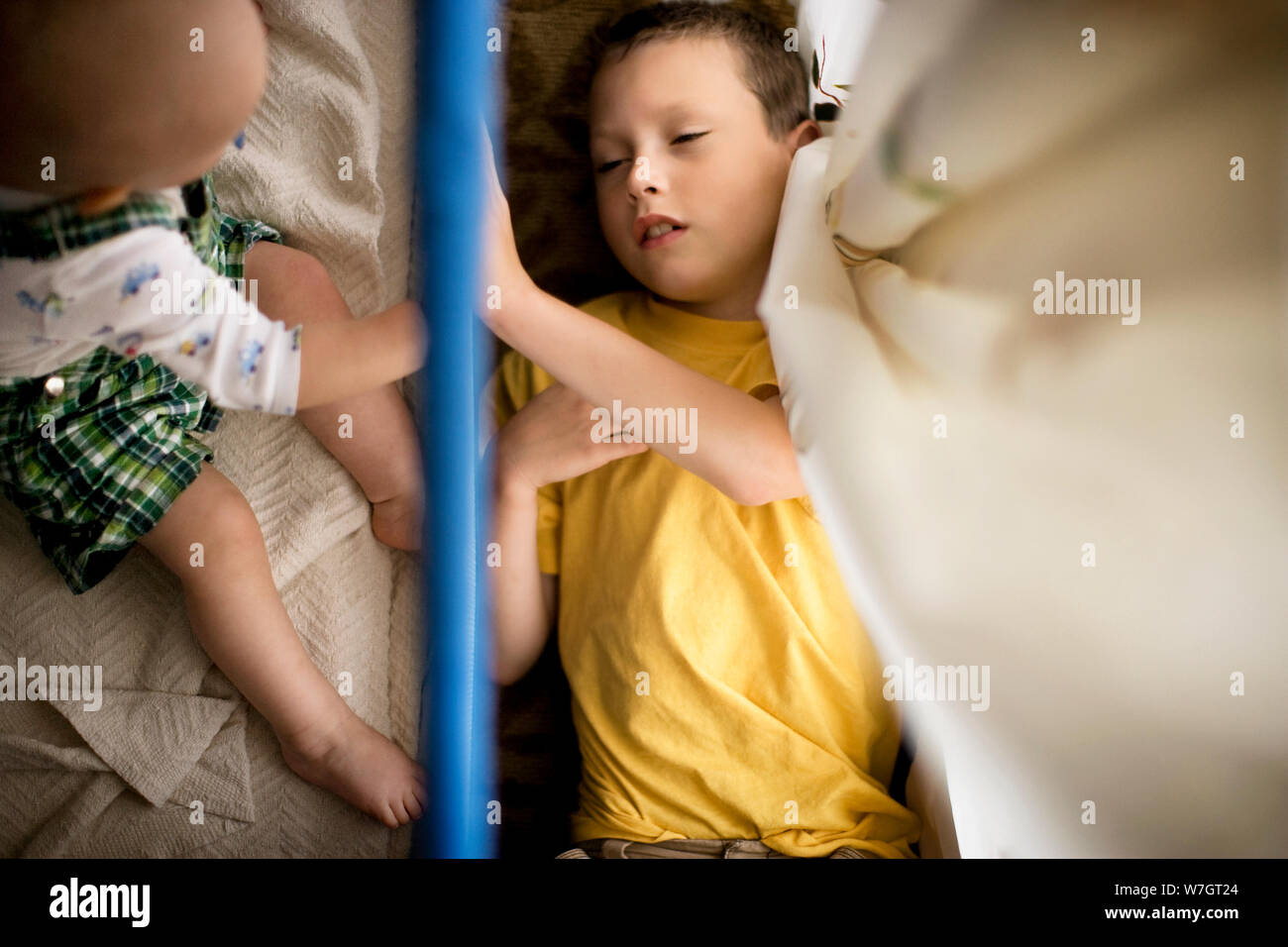Boy lying on the floor with his toddler brother. Stock Photo