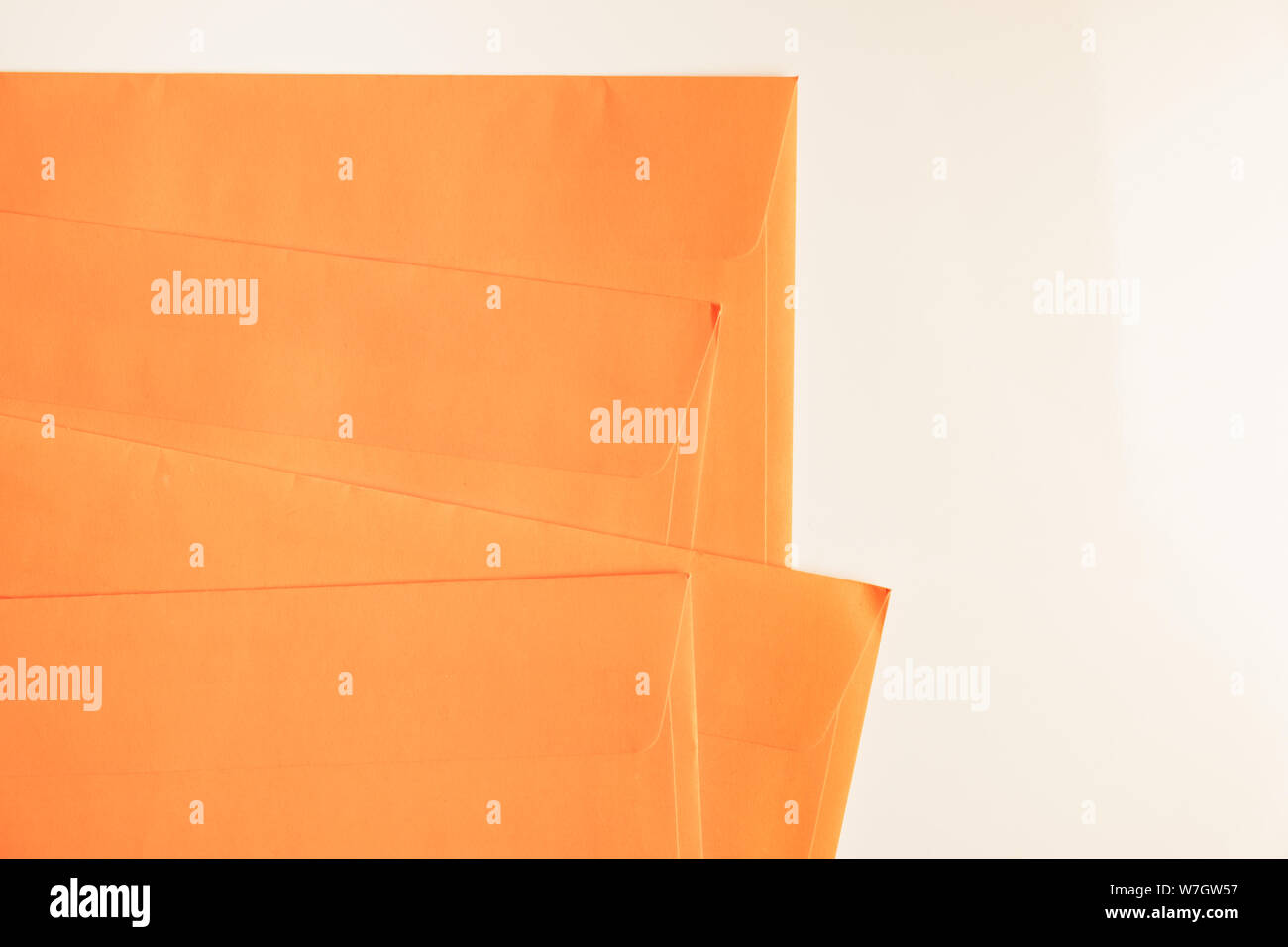 Orange envelopes in white background, top view. Abstract image of